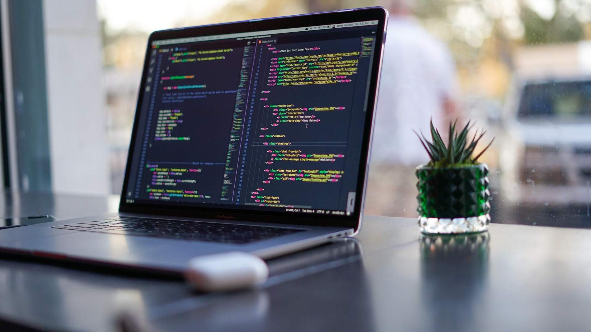 A laptop displaying code on a clean desk